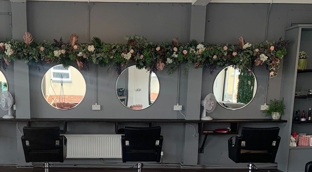 Modern styling stations at Euphoria Hair, Finedon, England, GB with floral decor.
