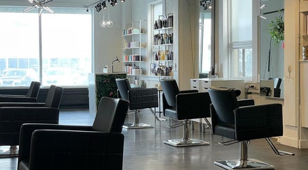 Modern salon interior at Honeycomb Hair Lounge, Regina, Saskatchewan, CA with sleek black chairs and bright decor.