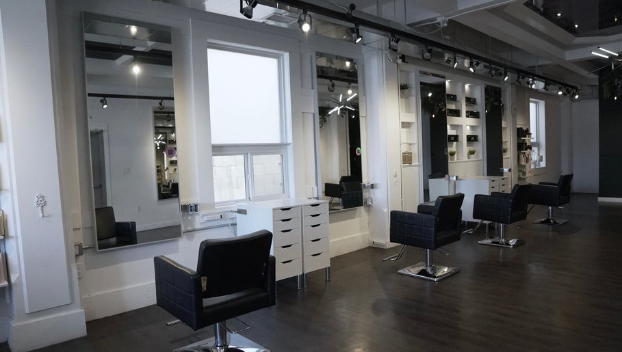 Modern salon interior at Honeycomb Hair Lounge, Regina, Saskatchewan, CA, featuring stylish chairs and mirrors.
