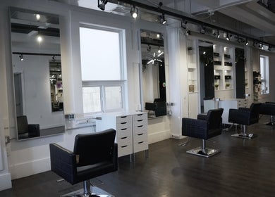 Modern salon interior at Honeycomb Hair Lounge, Regina, Saskatchewan, CA, featuring stylish chairs and mirrors.
