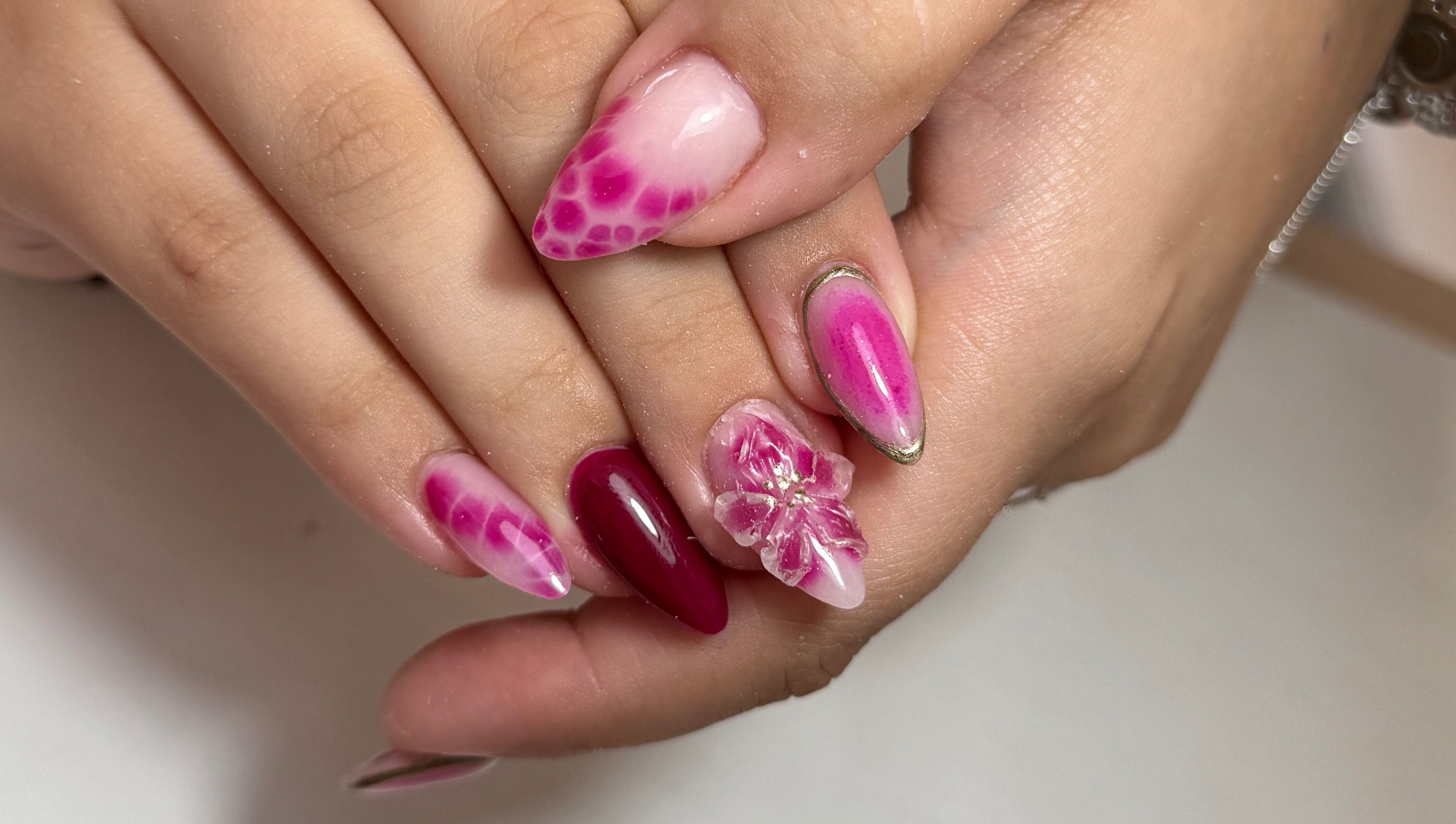 Vibrant pink nail art with floral designs at Nails LCB in Havant, England, GB.