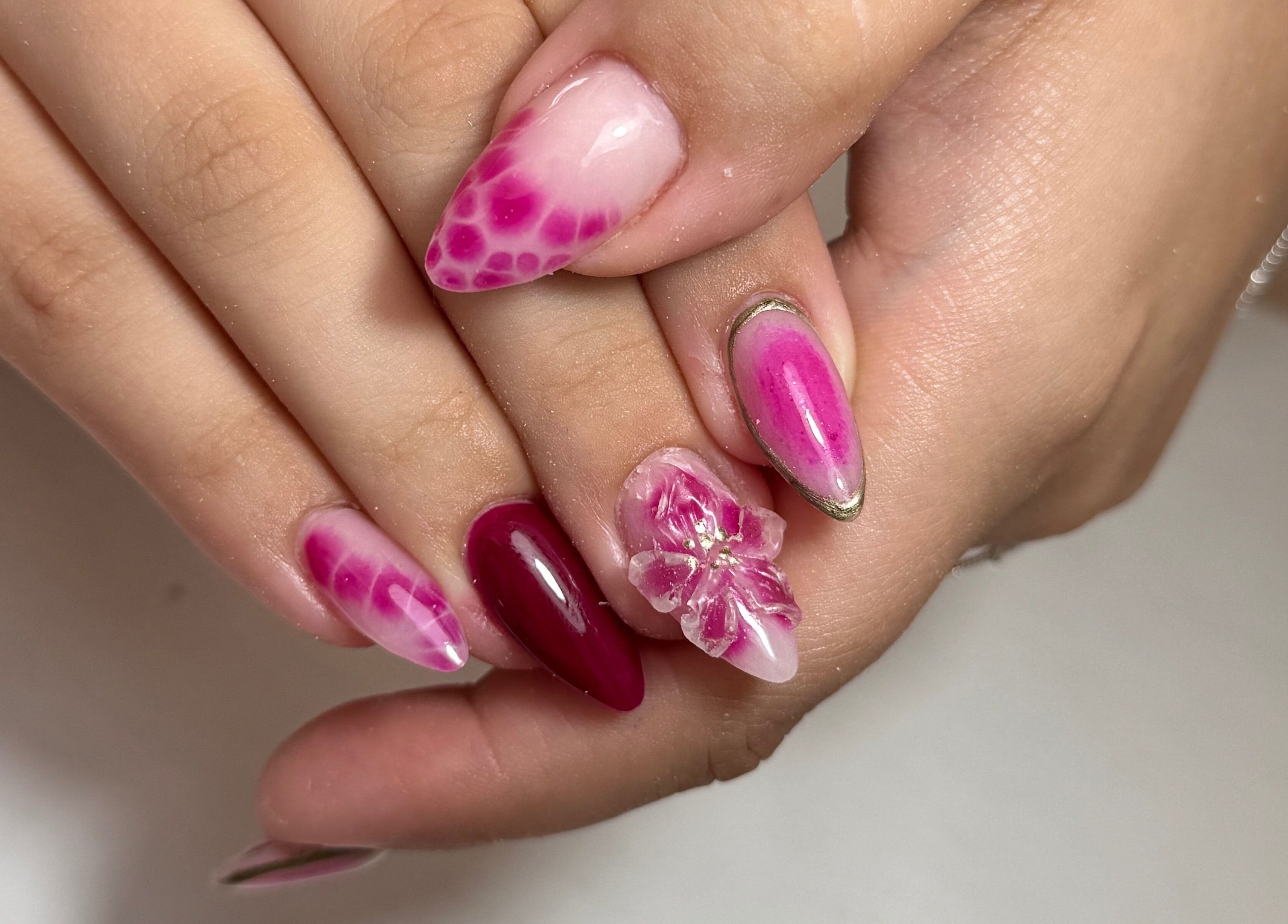 Vibrant pink nail art with floral designs at Nails LCB in Havant, England, GB.