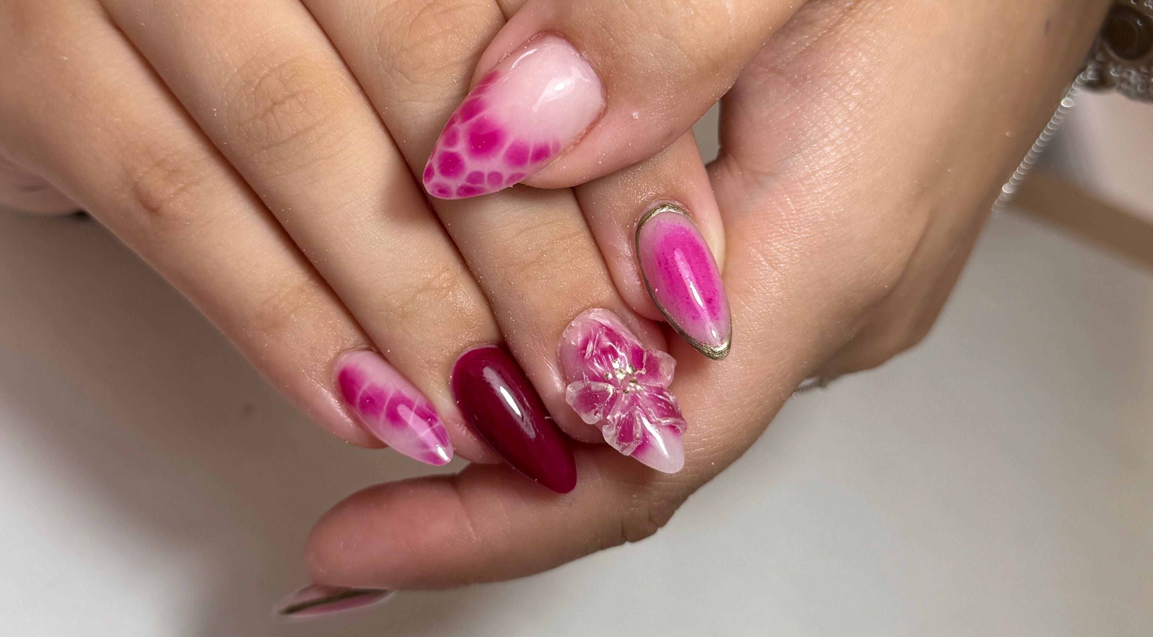 Vibrant pink nail art with floral designs at Nails LCB in Havant, England, GB.