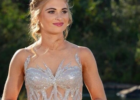 Woman in elegant gown at Go Brown Mpumpalanga - Nelspruit in Mbombela, Mpumalanga, ZA, with lush greenery backdrop.