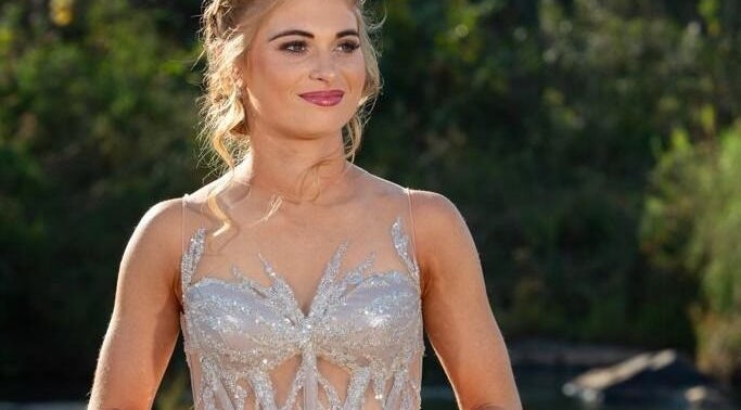 Woman in elegant gown at Go Brown Mpumpalanga - Nelspruit in Mbombela, Mpumalanga, ZA, with lush greenery backdrop.