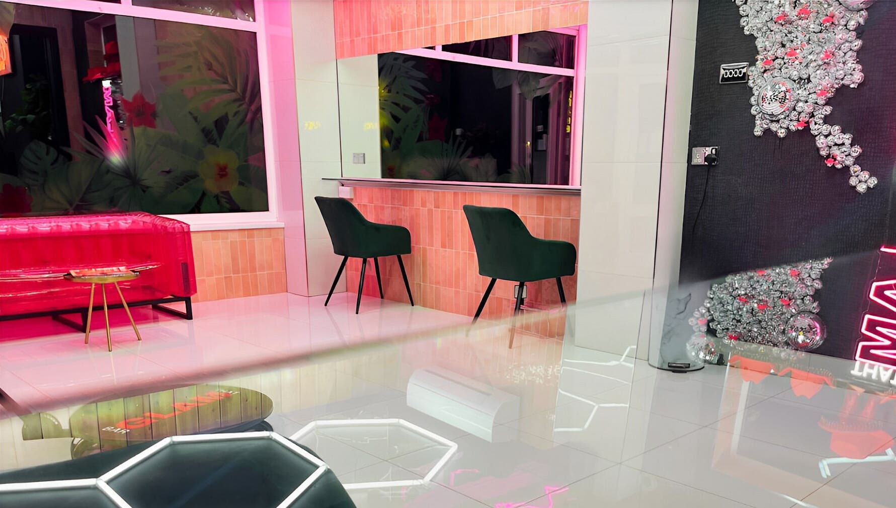 Chic interior of That Glam Bar Goring by Sea, Worthing, England, GB showcasing plush seating and neon decor.