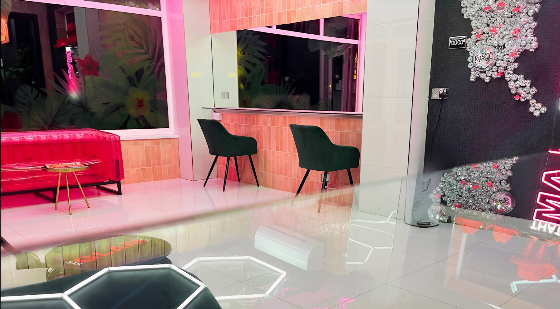 Chic interior of That Glam Bar Goring by Sea, Worthing, England, GB showcasing plush seating and neon decor.