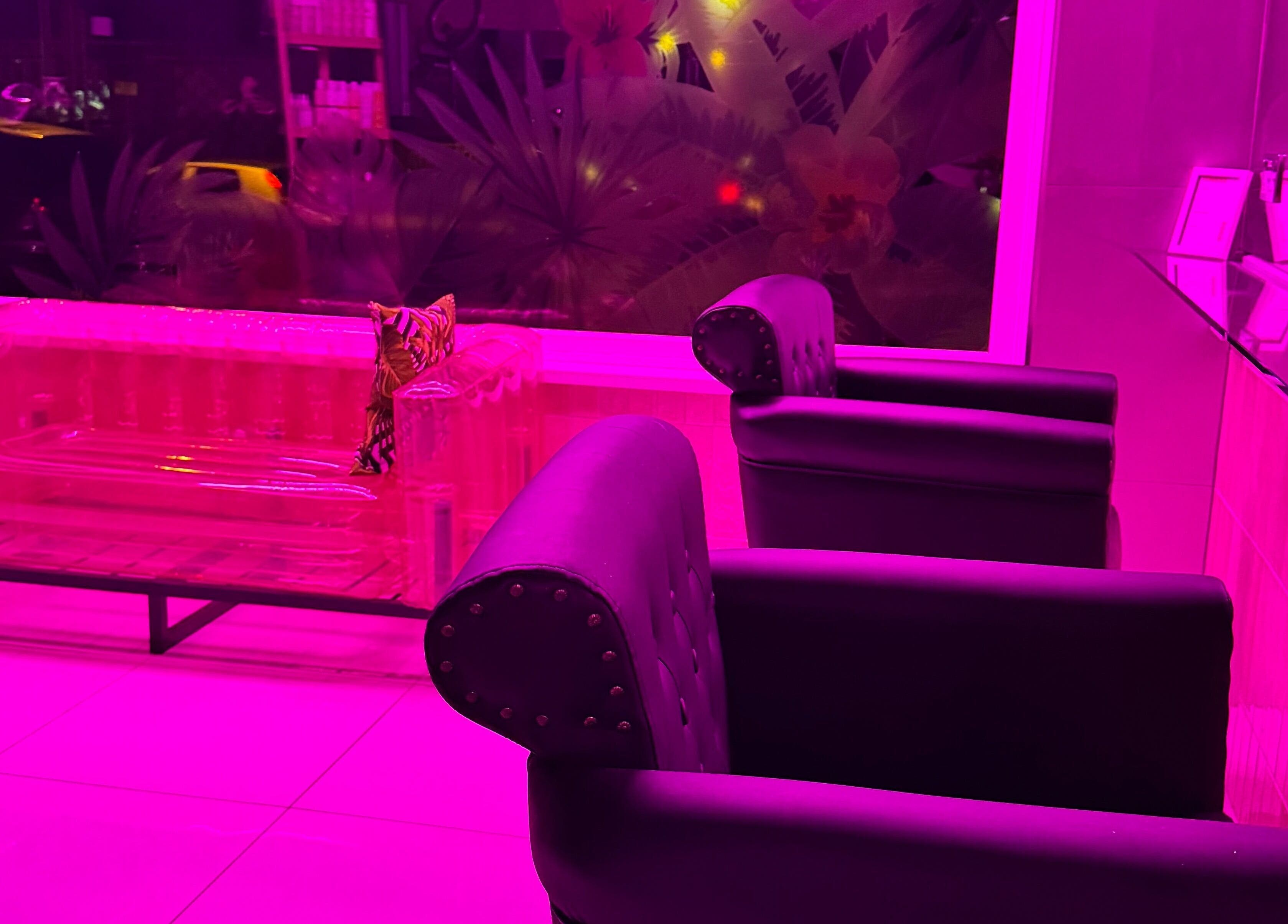 Chic lounge at That Glam Bar Goring by Sea, Worthing, England, GB in vibrant pink lighting.