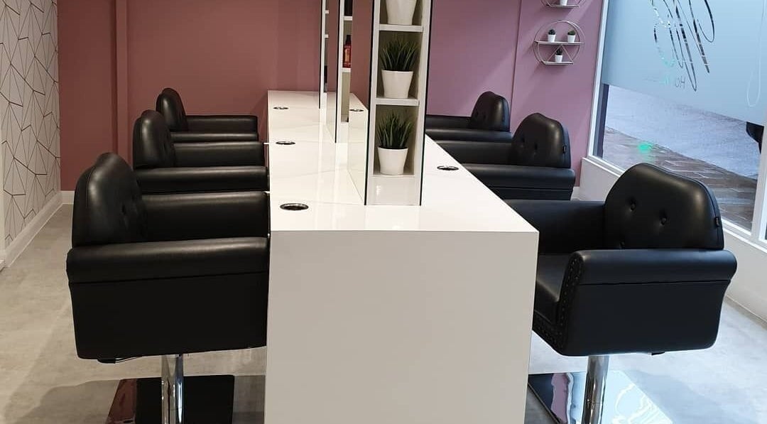 Elegant salon interior at Nikki Blanchford Hair & Beauty, Crediton, England, GB showcasing stylish black chairs.
