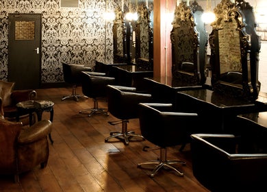 Elegant interior of Hayato London salon in London, England, GB with chic mirrors and leather chairs.