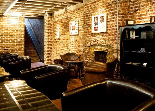 Cozy lounge with leather chairs and brick walls at Hayato London, London, England, GB.