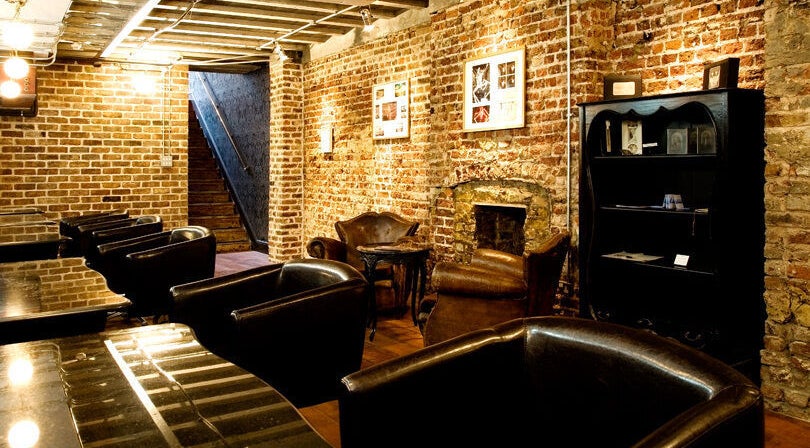 Cozy lounge with leather chairs and brick walls at Hayato London, London, England, GB.