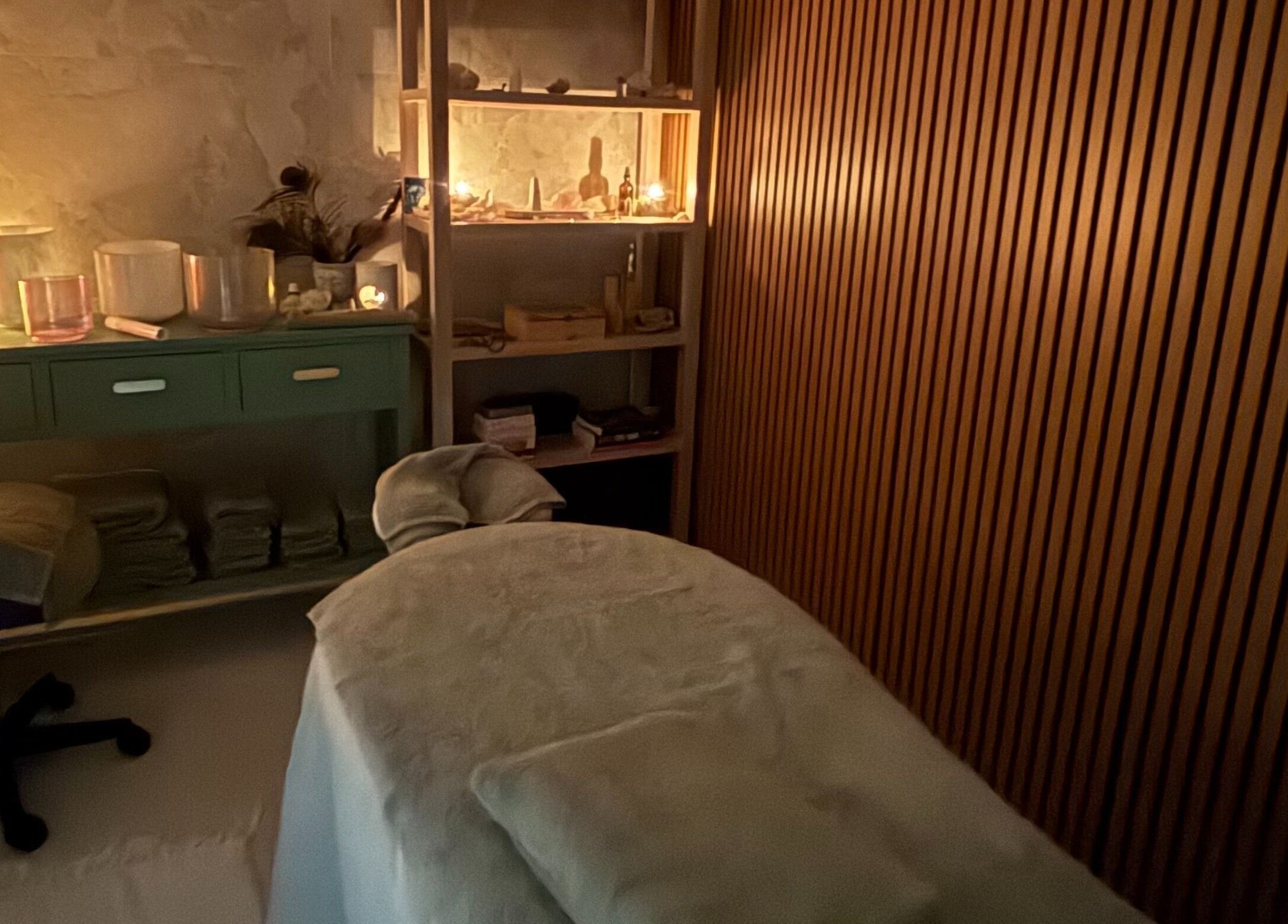 Cozy massage room ambience at The Healing Cottage, Palm Beach, Queensland, AU. Candles and soft lighting create tranquility.