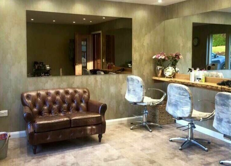 Elegant salon interior at Beautyme, Bathgate, Scotland, GB with a cozy brown leather sofa and styling chairs.