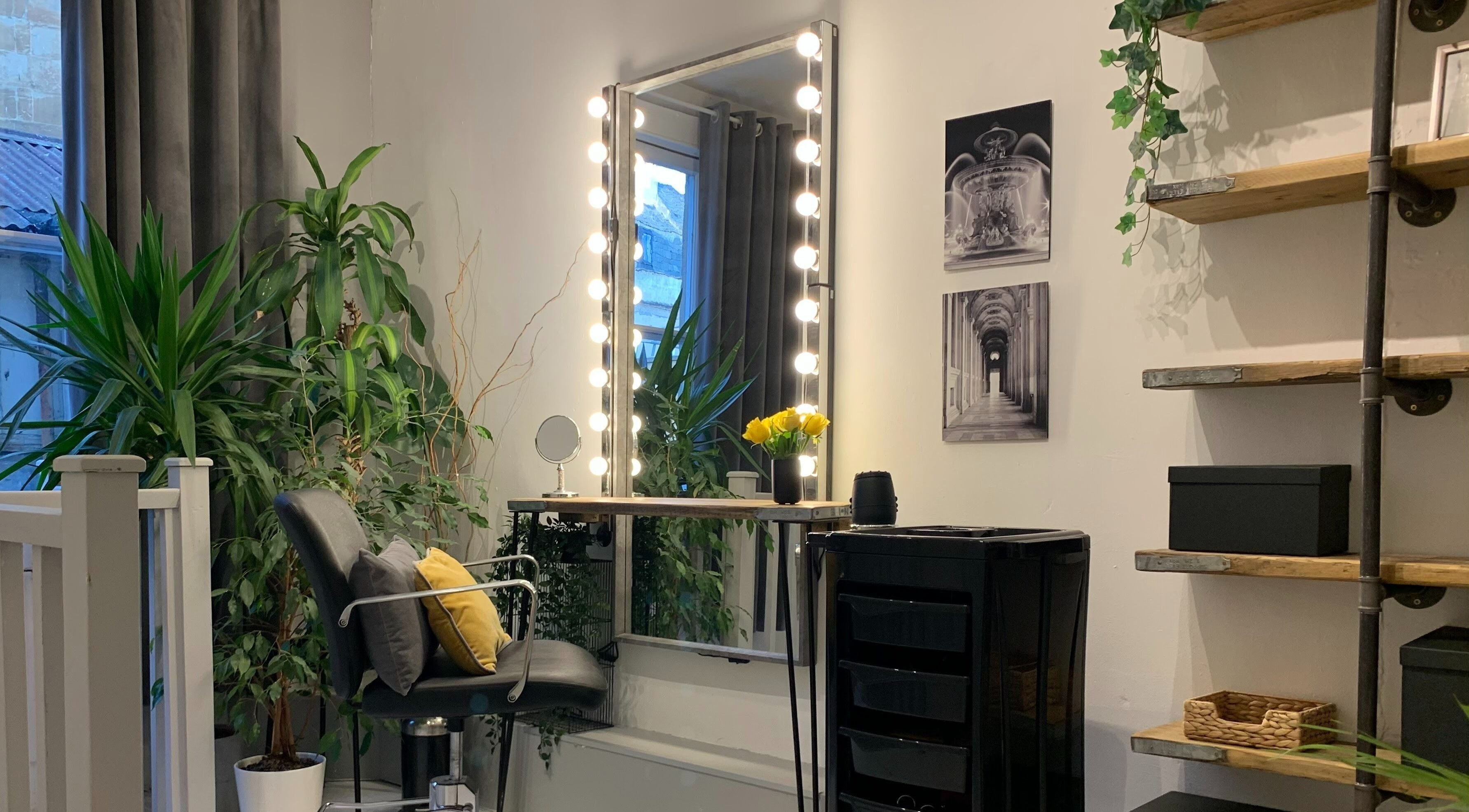 Elegant styling area at La Déesse Beauty Loft in Bath, England, GB with illuminated mirror and lush decor.