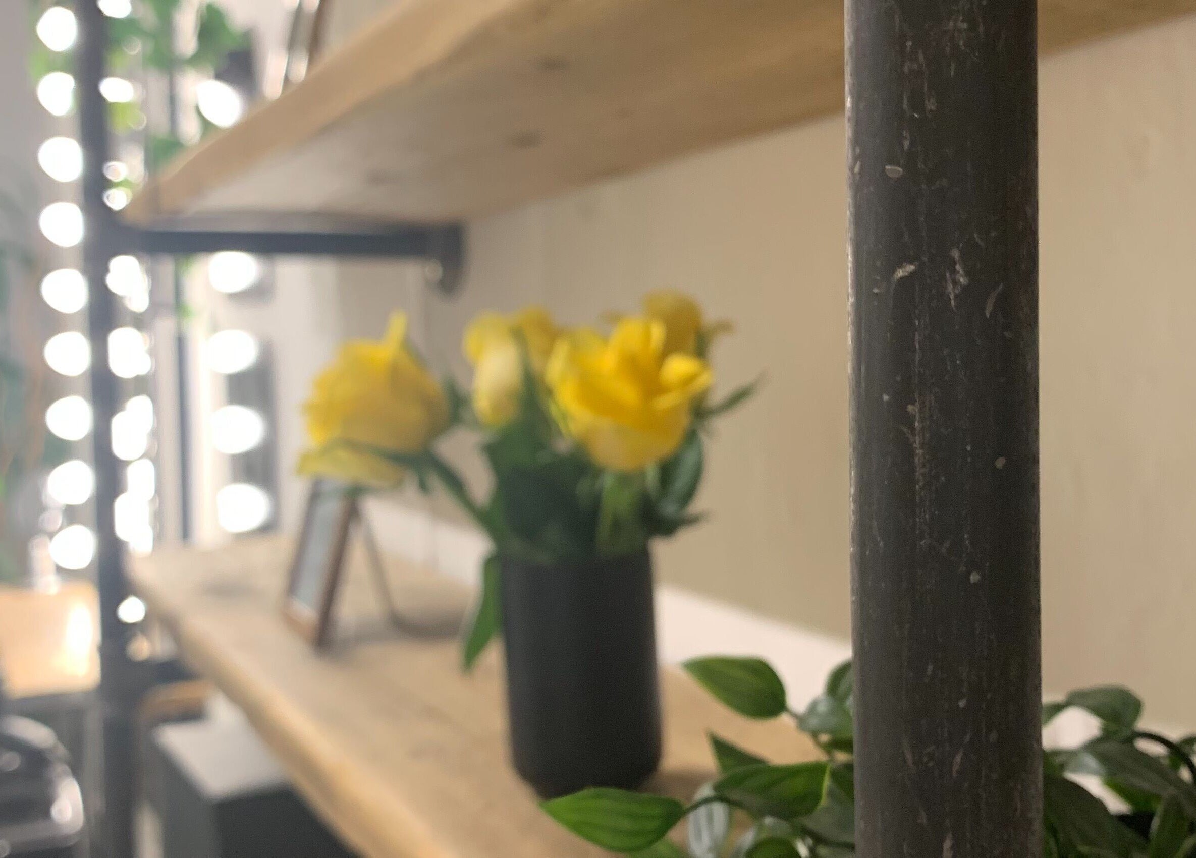 Yellow flowers on rustic shelf at La Déesse Beauty Loft, Bath, England, GB, creating serene ambiance.