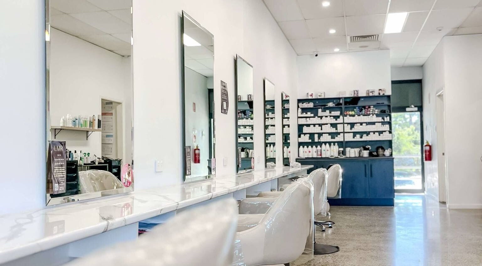 Spacious mirrors line Lily Me Red - CARRARA salon in Carrara, Queensland, AU showcasing a modern, clean design.
