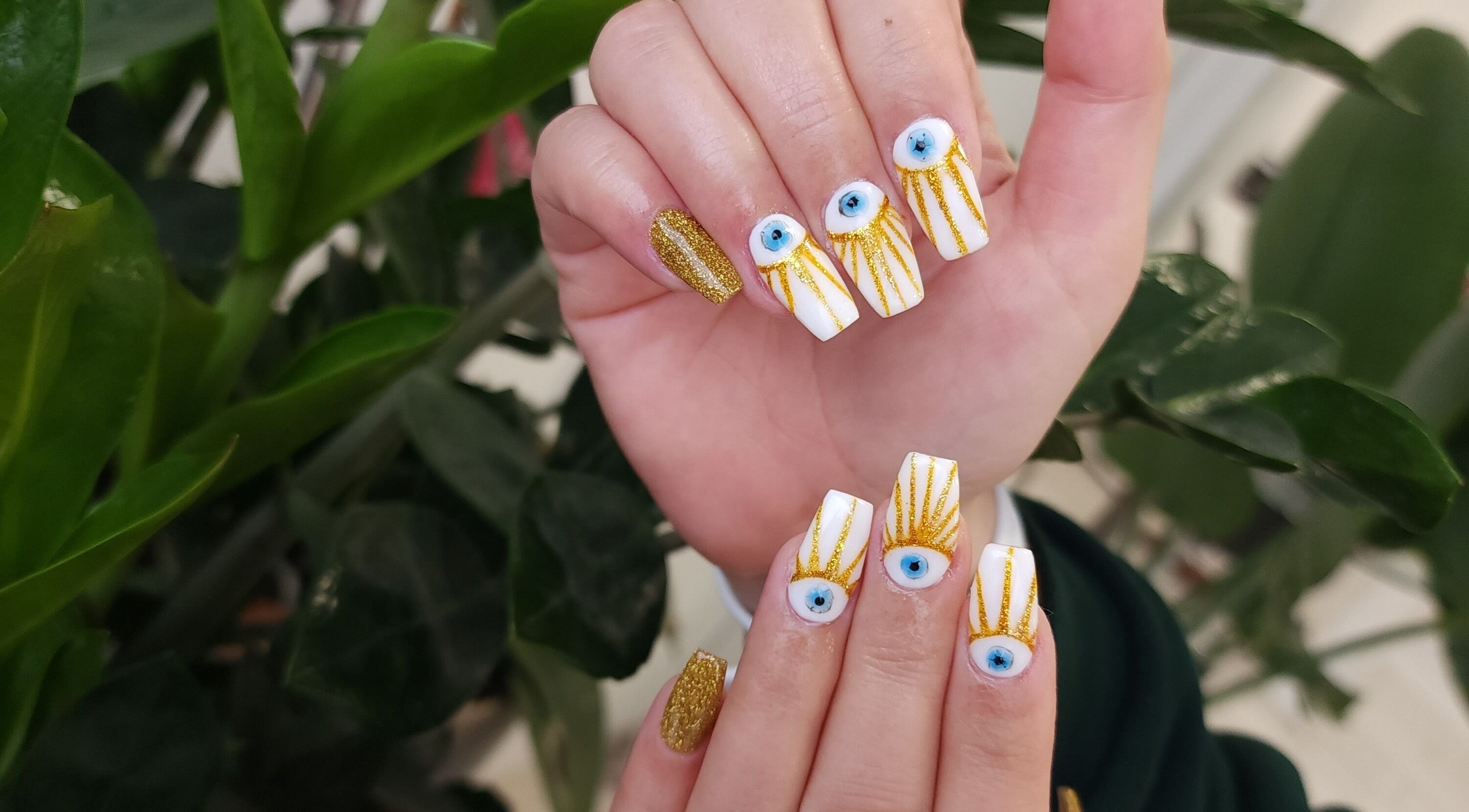 Intricate eye and gold glitter nail art at Serena Nails and Spa, Burlington, Massachusetts, US.