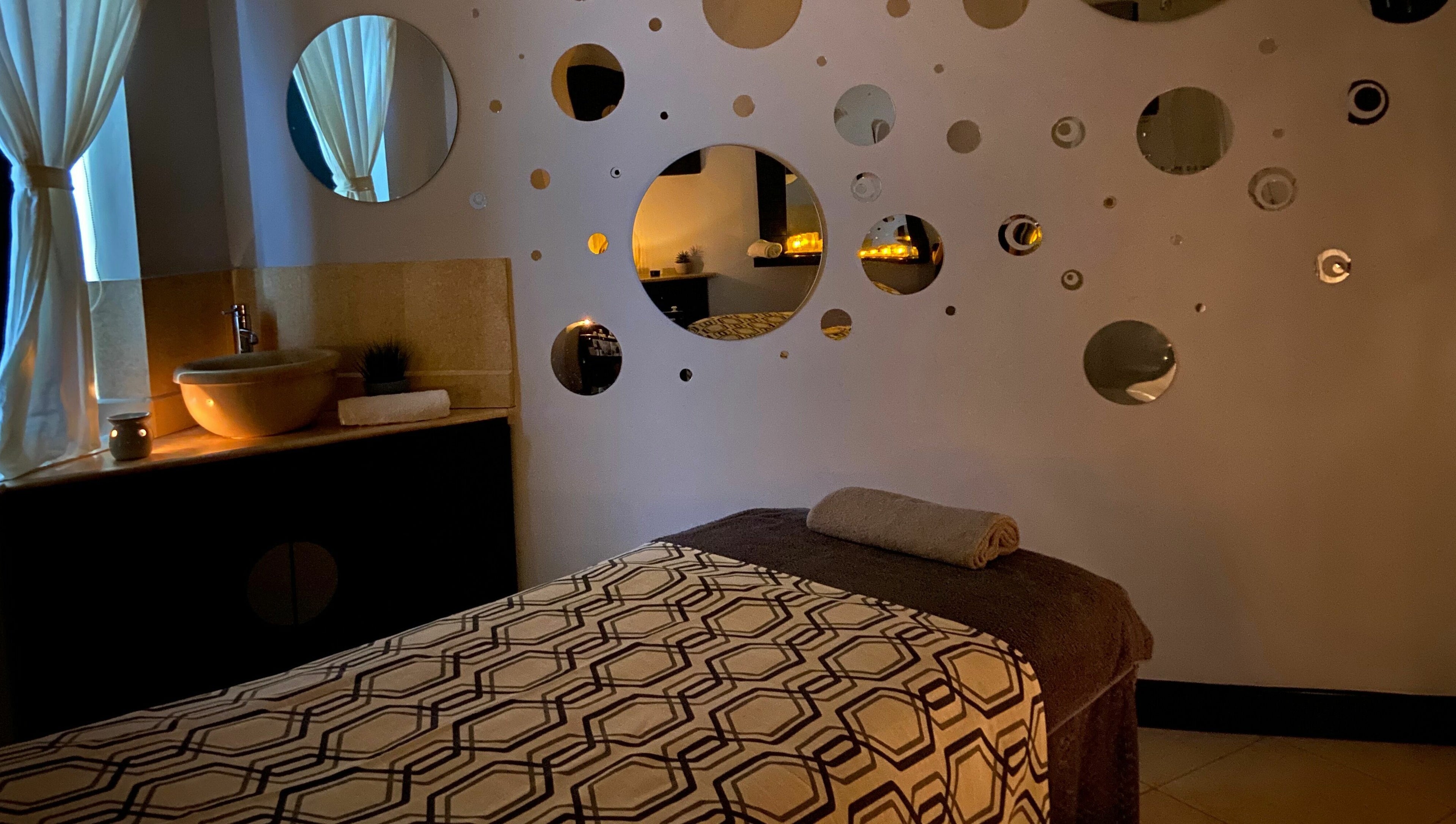 Serene treatment room at The Spa at St Giles, Norwich, England, GB with warm lighting and unique wall decor.