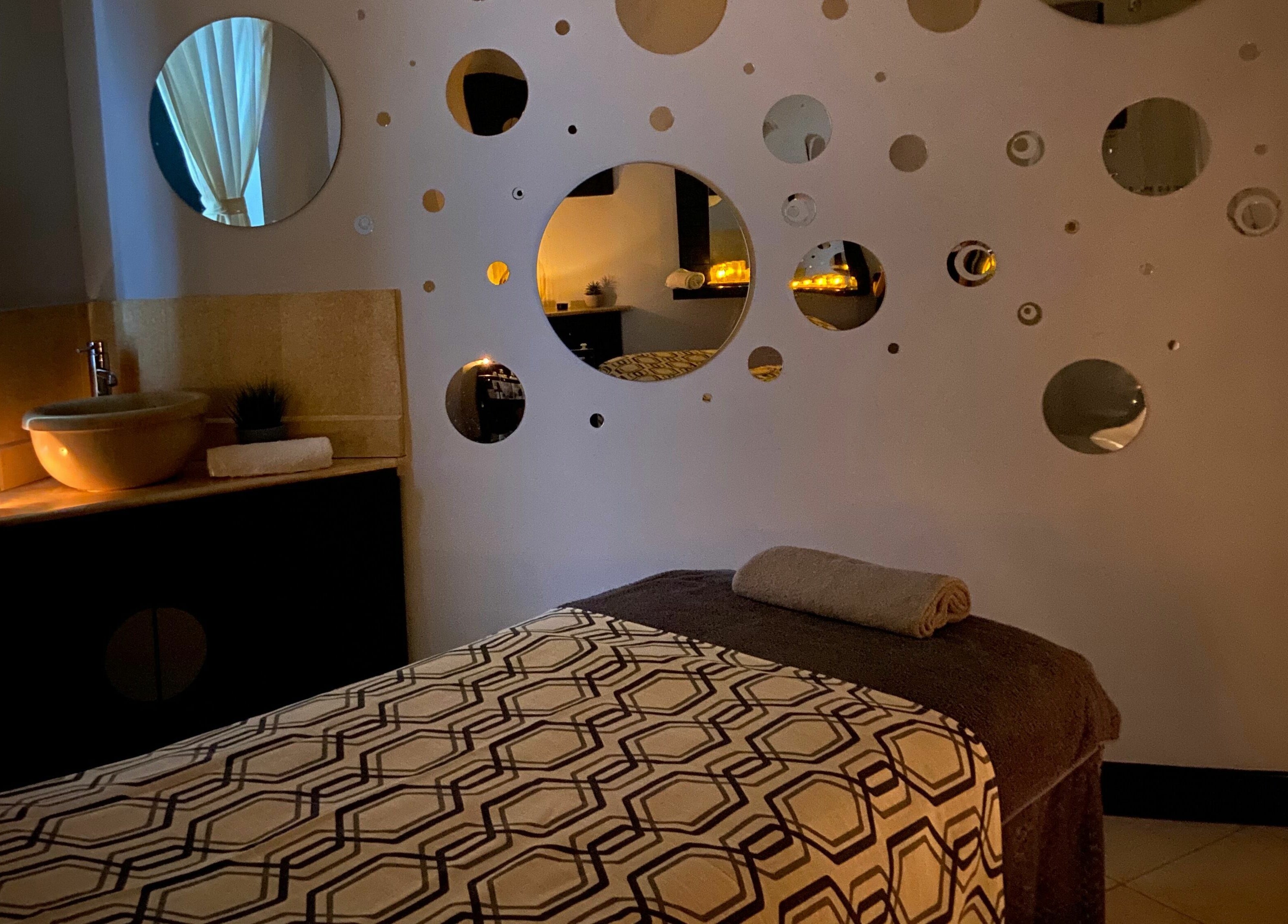 Serene treatment room at The Spa at St Giles, Norwich, England, GB with warm lighting and unique wall decor.