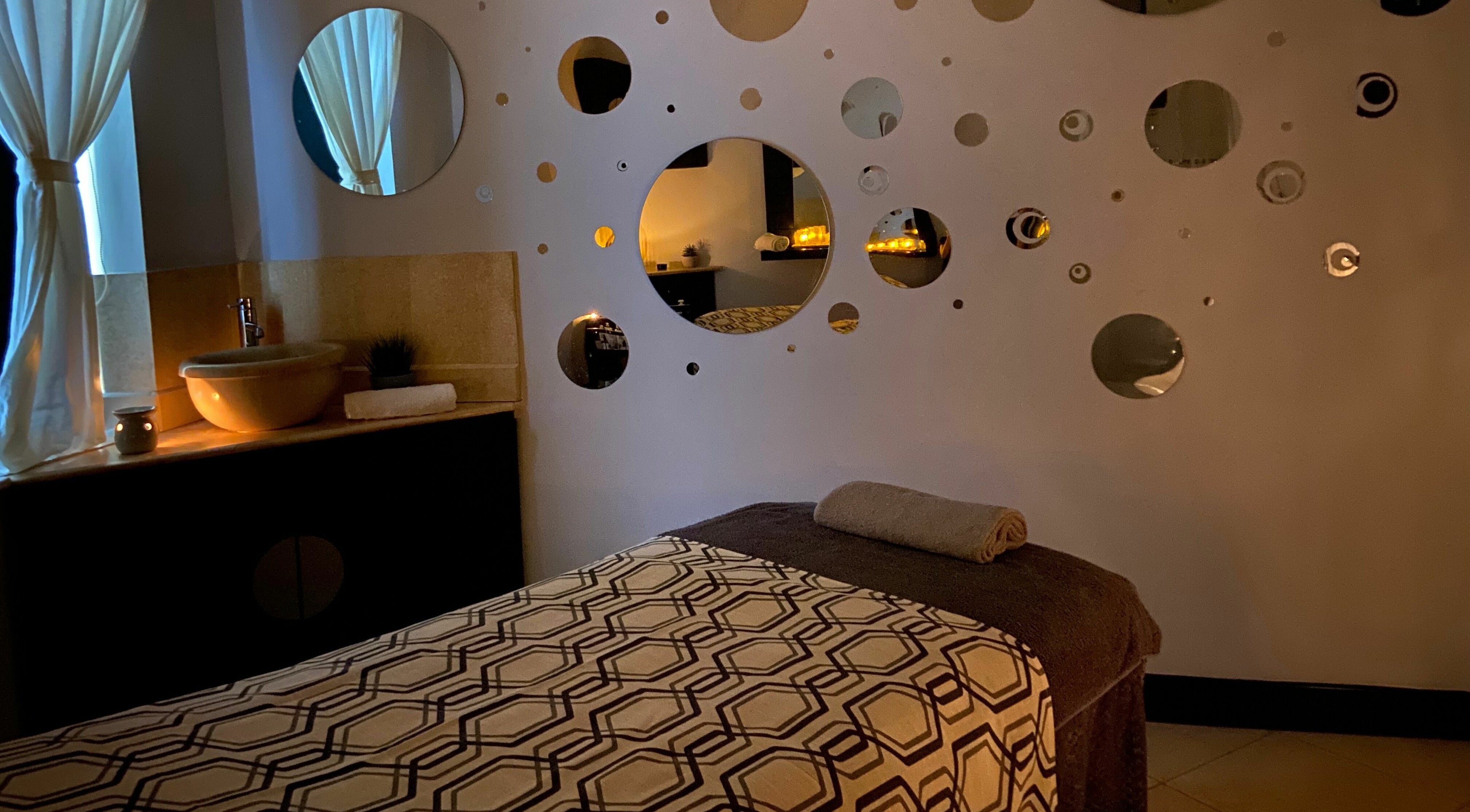 Serene treatment room at The Spa at St Giles, Norwich, England, GB with warm lighting and unique wall decor.