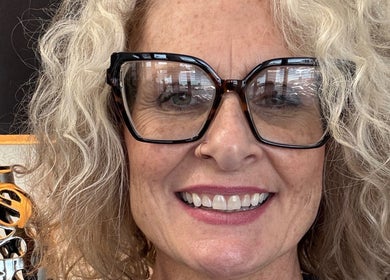 Blonde woman smiling with stylish glasses at Hair by Angelia Chandler Austin, Jonesboro, Arkansas, US.