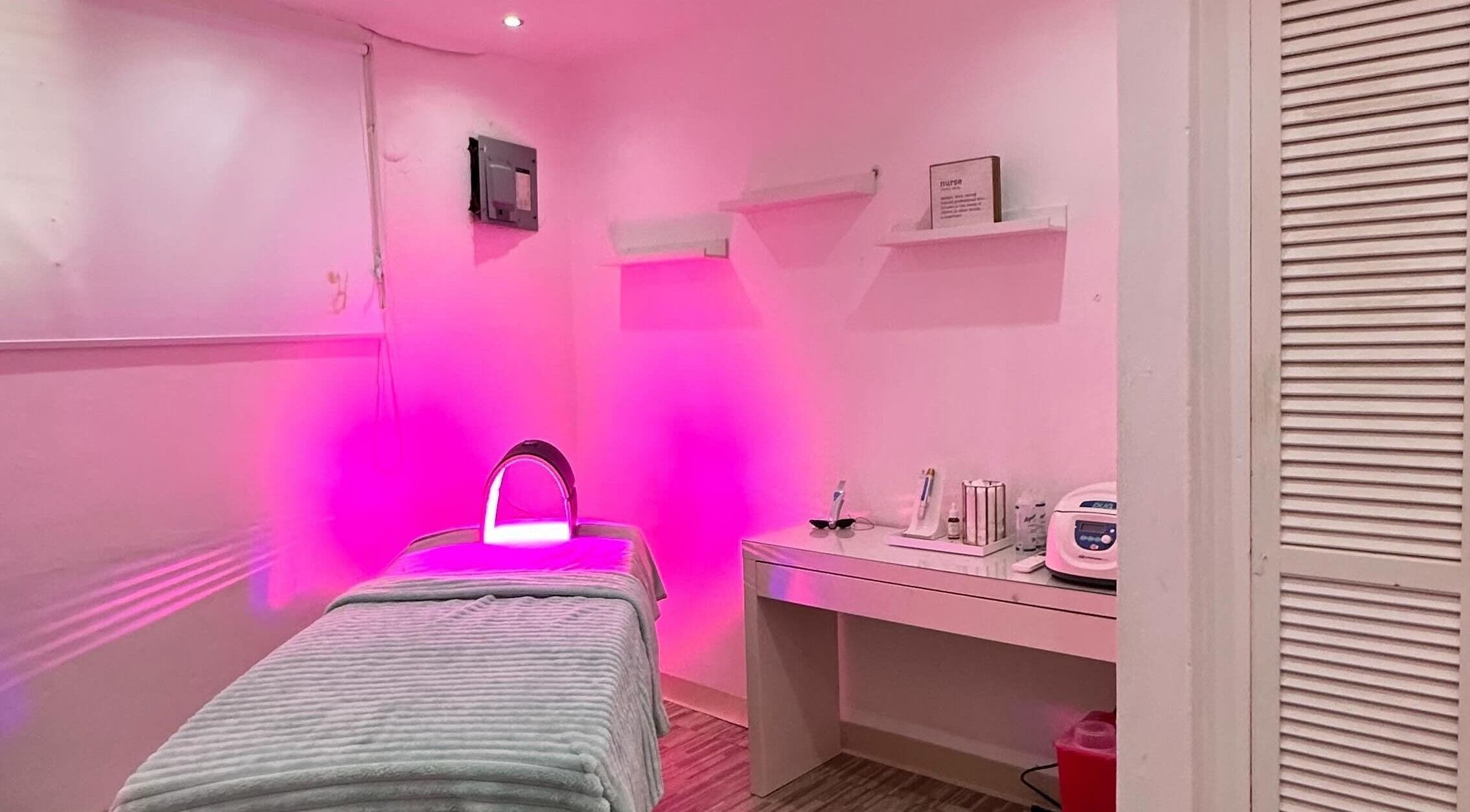Habitación de spa en Blu Room Spa, Guaynabo, PR, con iluminación rosa y cama de tratamiento.
