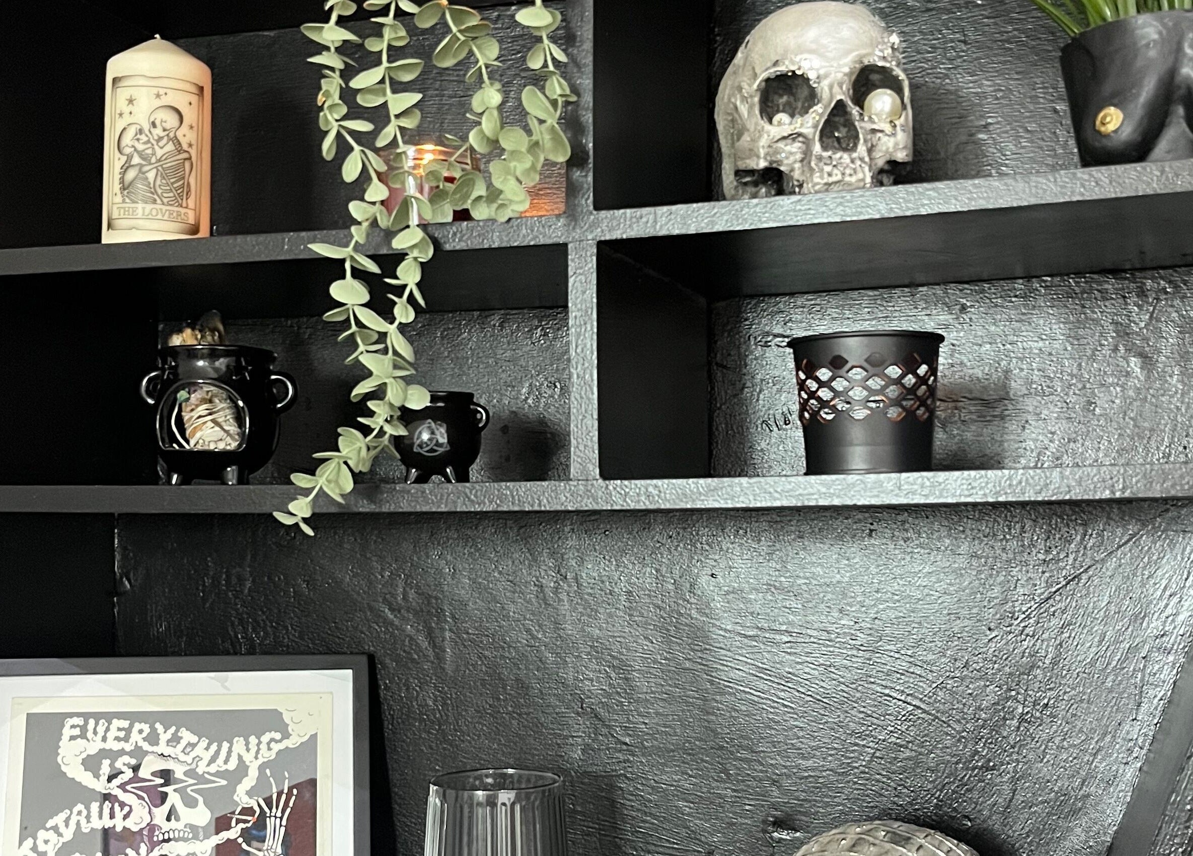 Stylish gothic shelf decor at Kath Mulhall Brows in Dublin, County Dublin, IE featuring skull and candles.