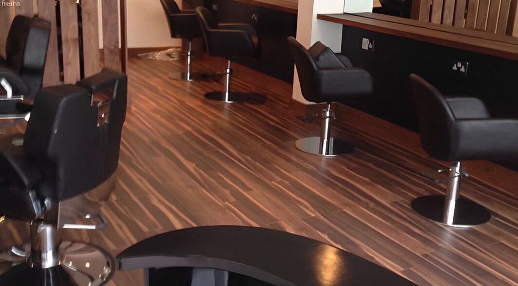 Chic interior of Kimoys Unisex Hair Salon in Gravesend, England, GB with sleek black styling chairs.