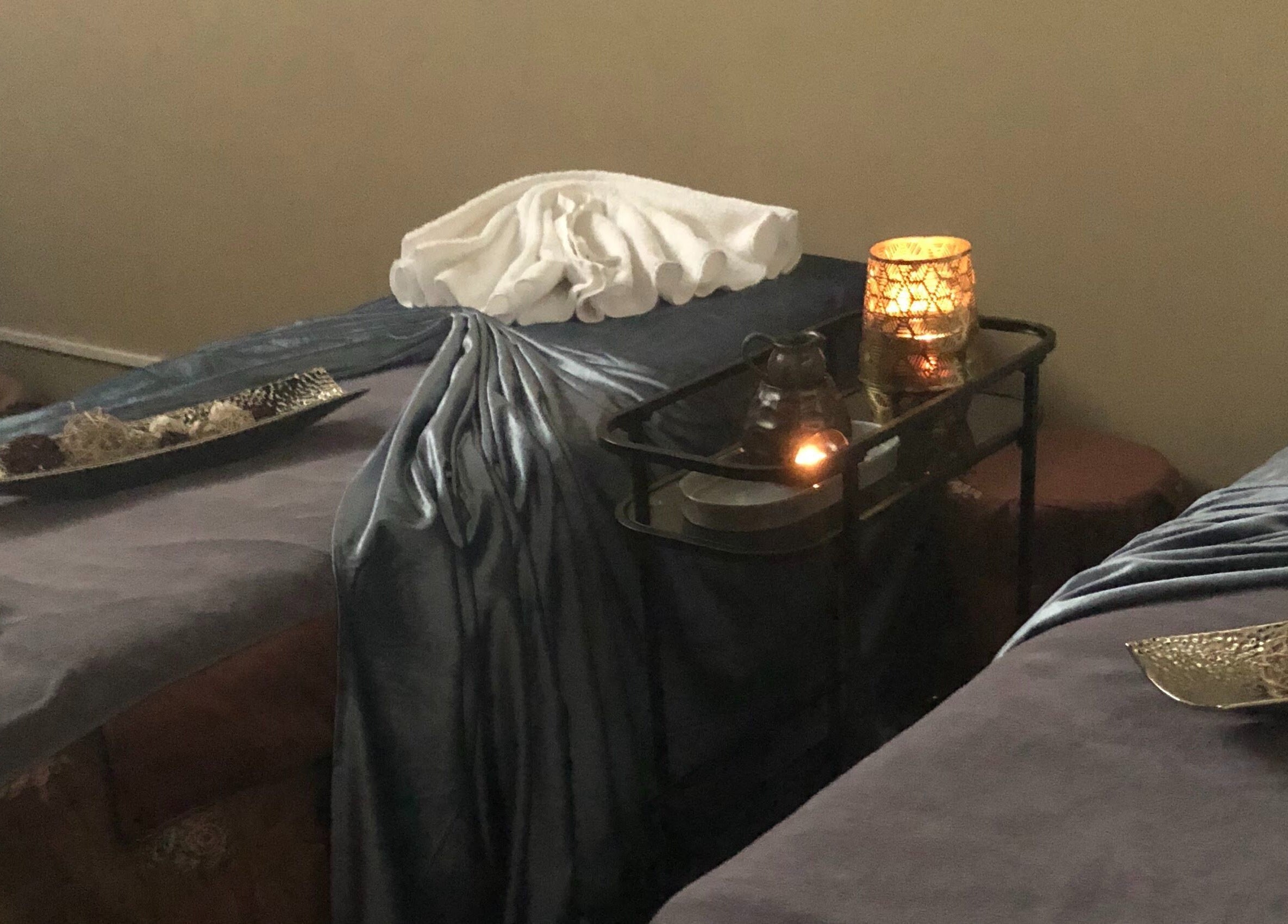 Peaceful spa setting with massage beds and candles at Relaxury, Auckland, Auckland, NZ, offering ultimate relaxation.