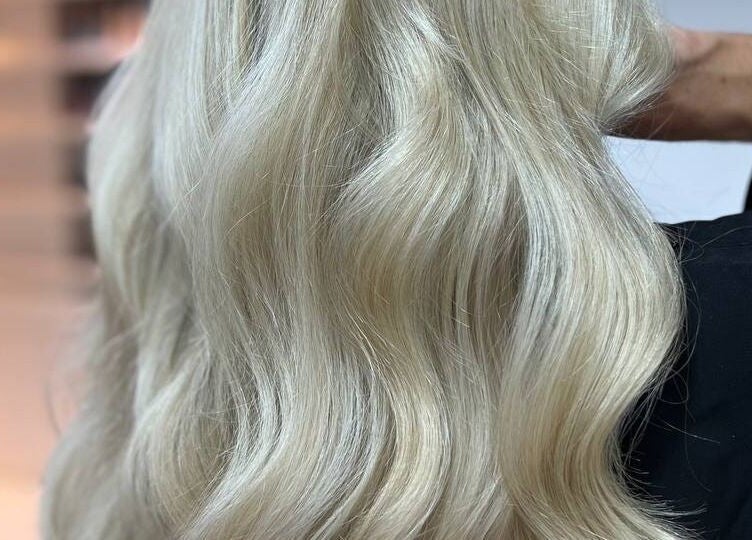 Elegant platinum blonde waves styled at Beauty Hunters The Pearl, Doha, QA, showcasing expert hair artistry.