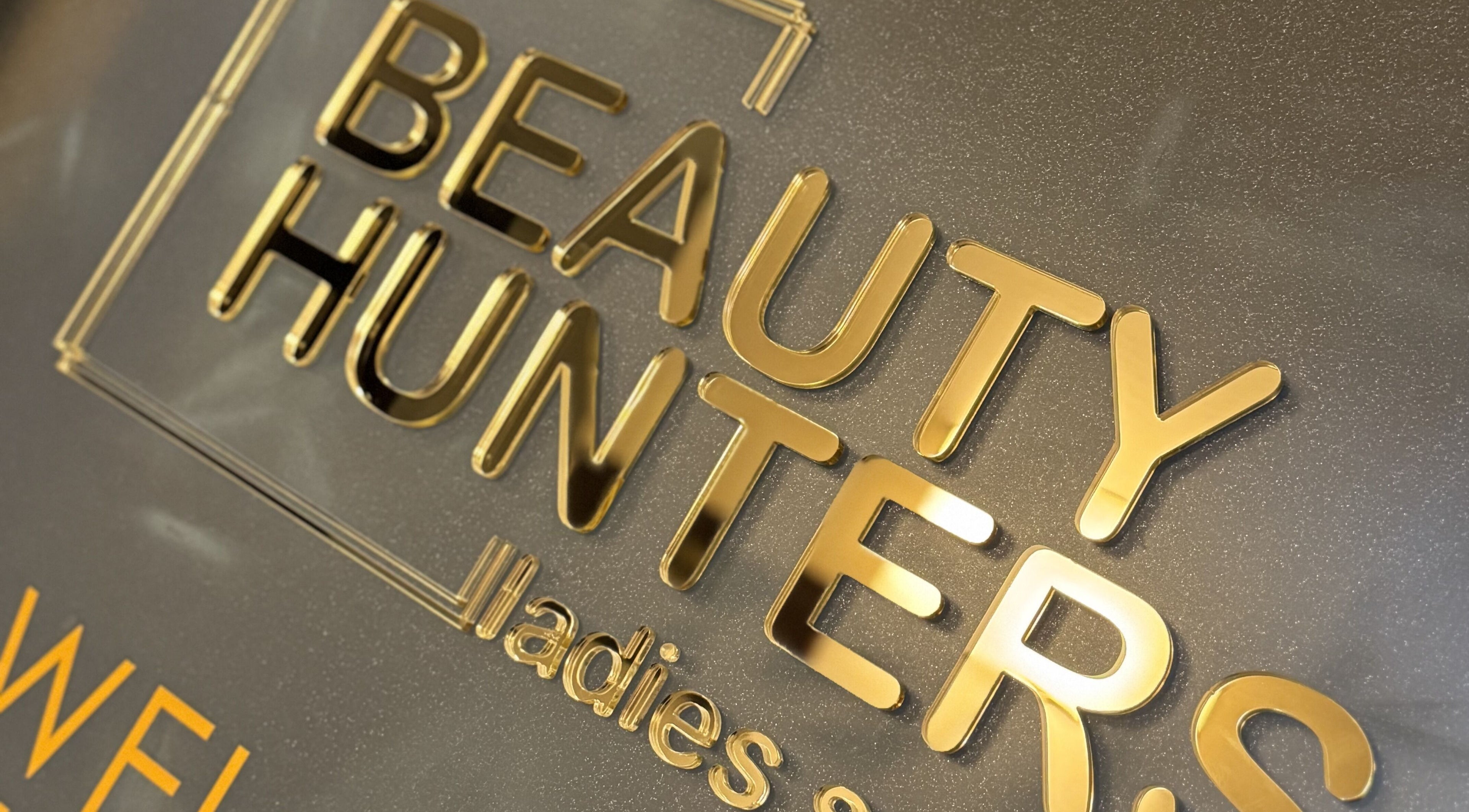 Gold Beauty Hunters West Bay sign in Doha, Doha Municipality, QA showing luxury aesthetic.