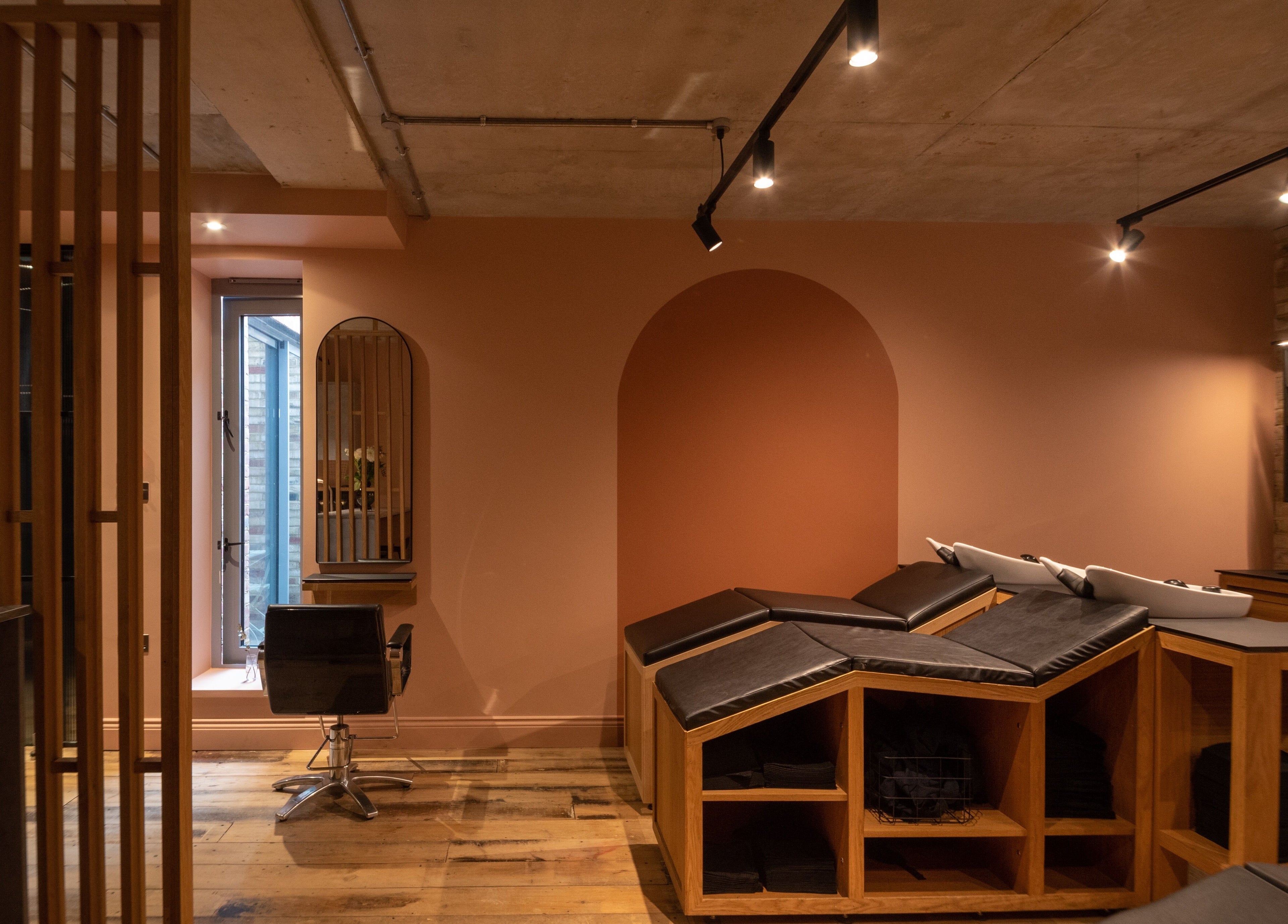 Modern salon interior at Bond in London, England, GB, featuring sleek chairs and ambient lighting.