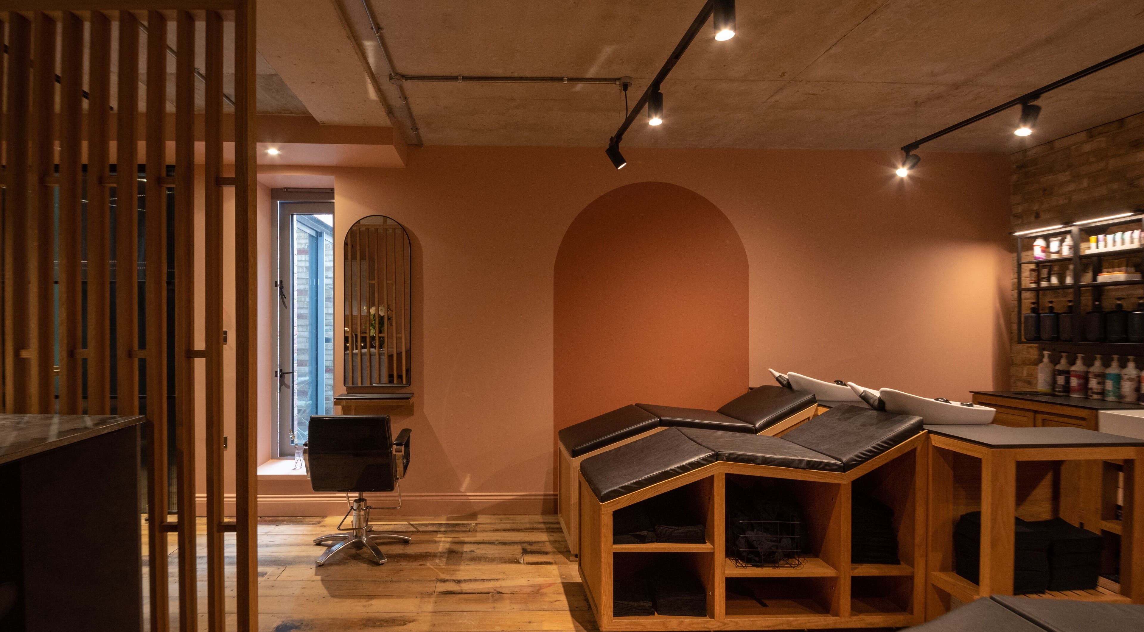 Modern salon interior at Bond in London, England, GB, featuring sleek chairs and ambient lighting.