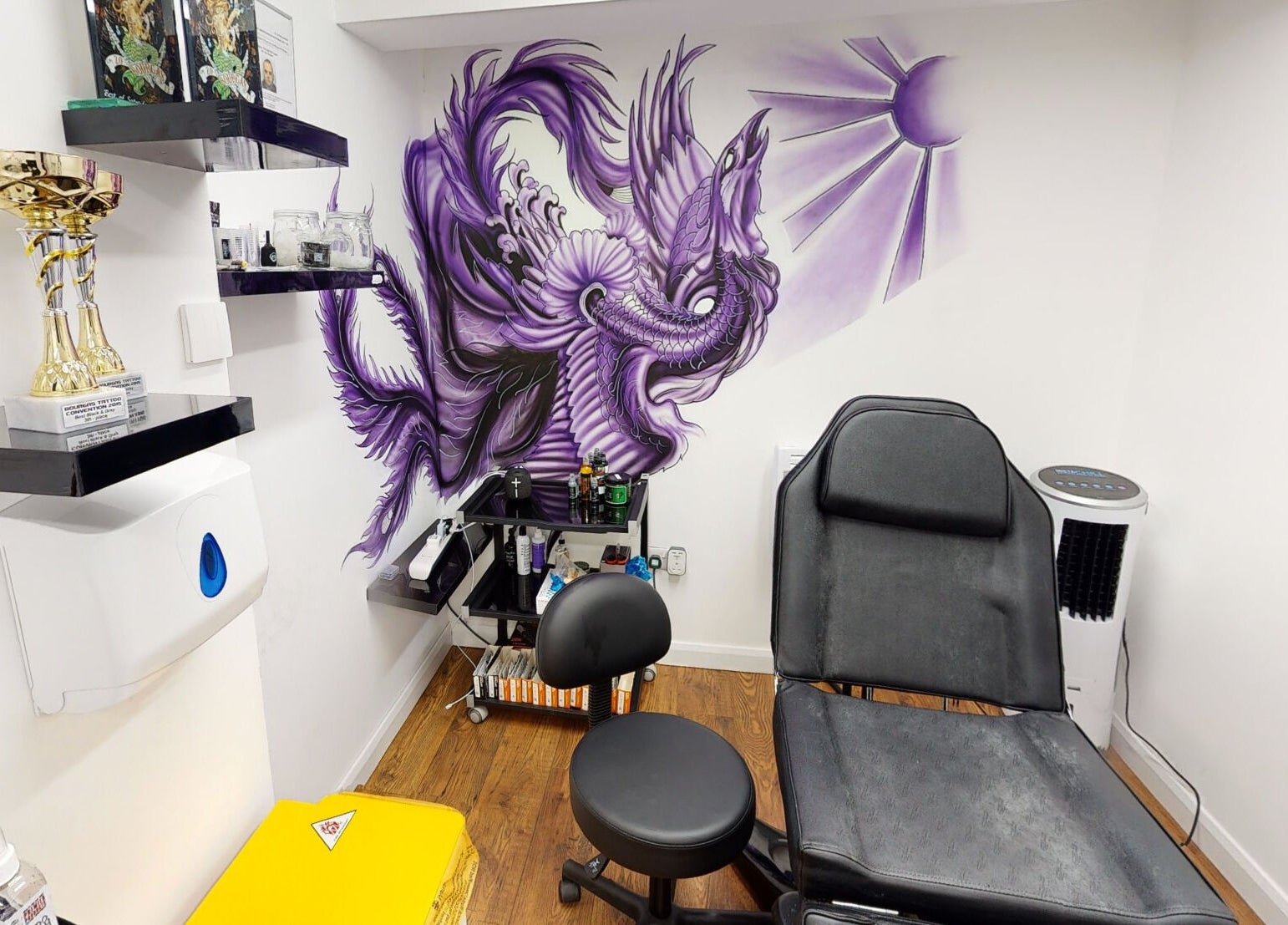 Tattoo room at The Avalon Rooms, Witney, England, GB. Features awards and a vibrant purple mural.