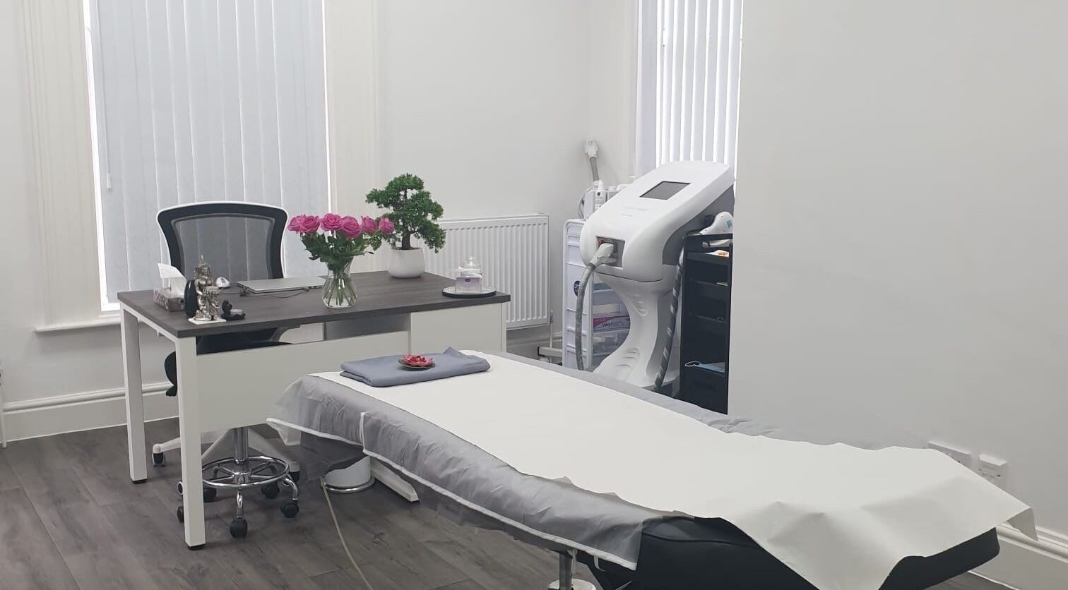Bright treatment room at Escala Beauty, Bolton, England, GB with flowers and modern equipment.
