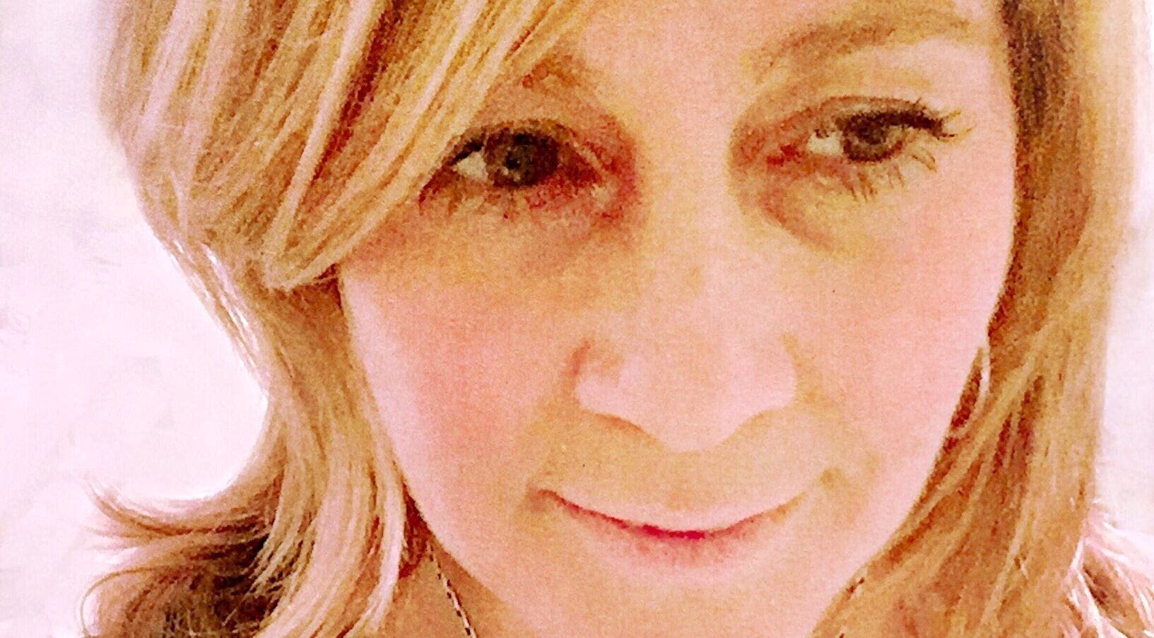 Close-up of a smiling individual at Radiant You, Massage & Coaching in San Anselmo, California, US.