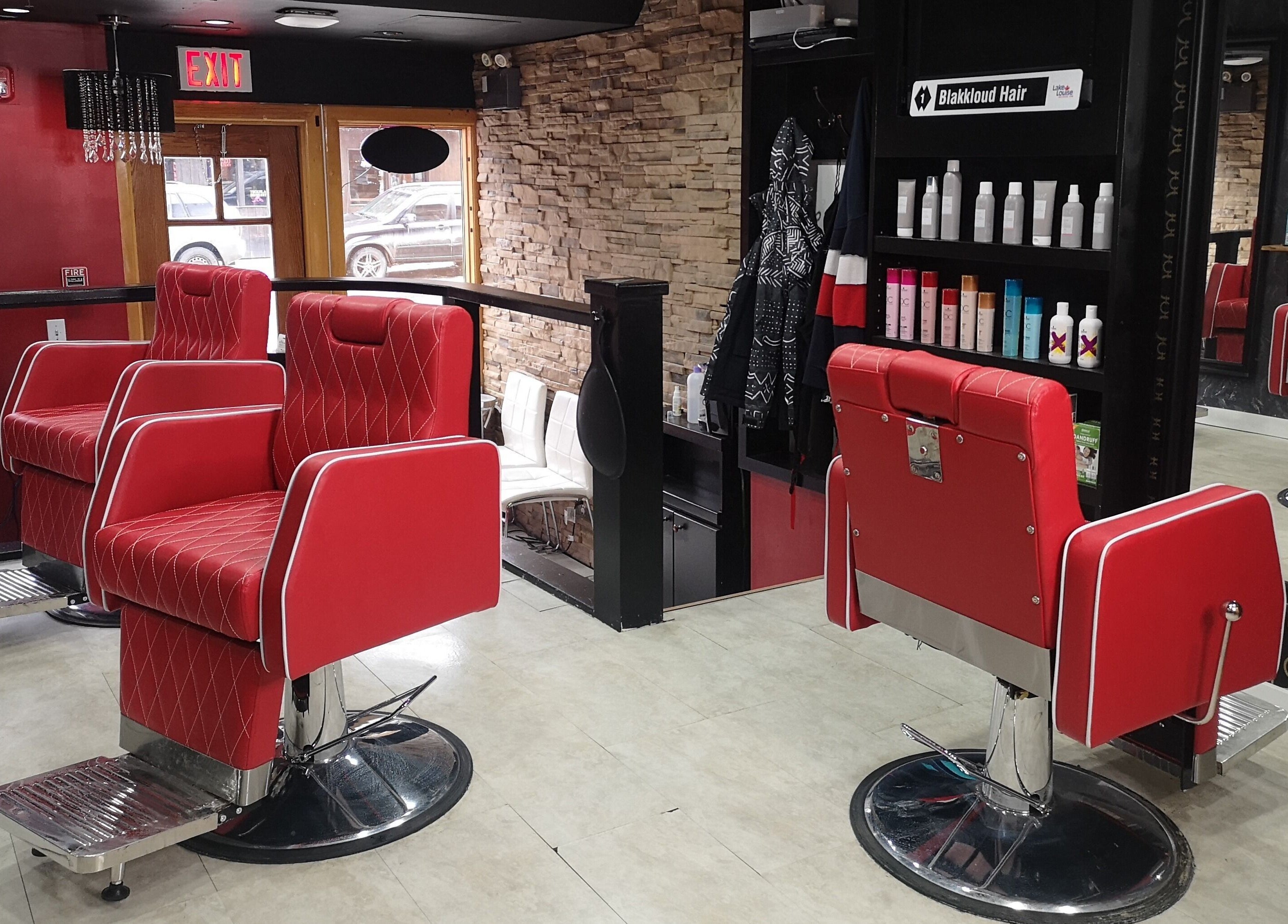 Chic red salon chairs at Blakkloud, Banff, Alberta, CA. Luxury ambiance with stone wall and products displayed.