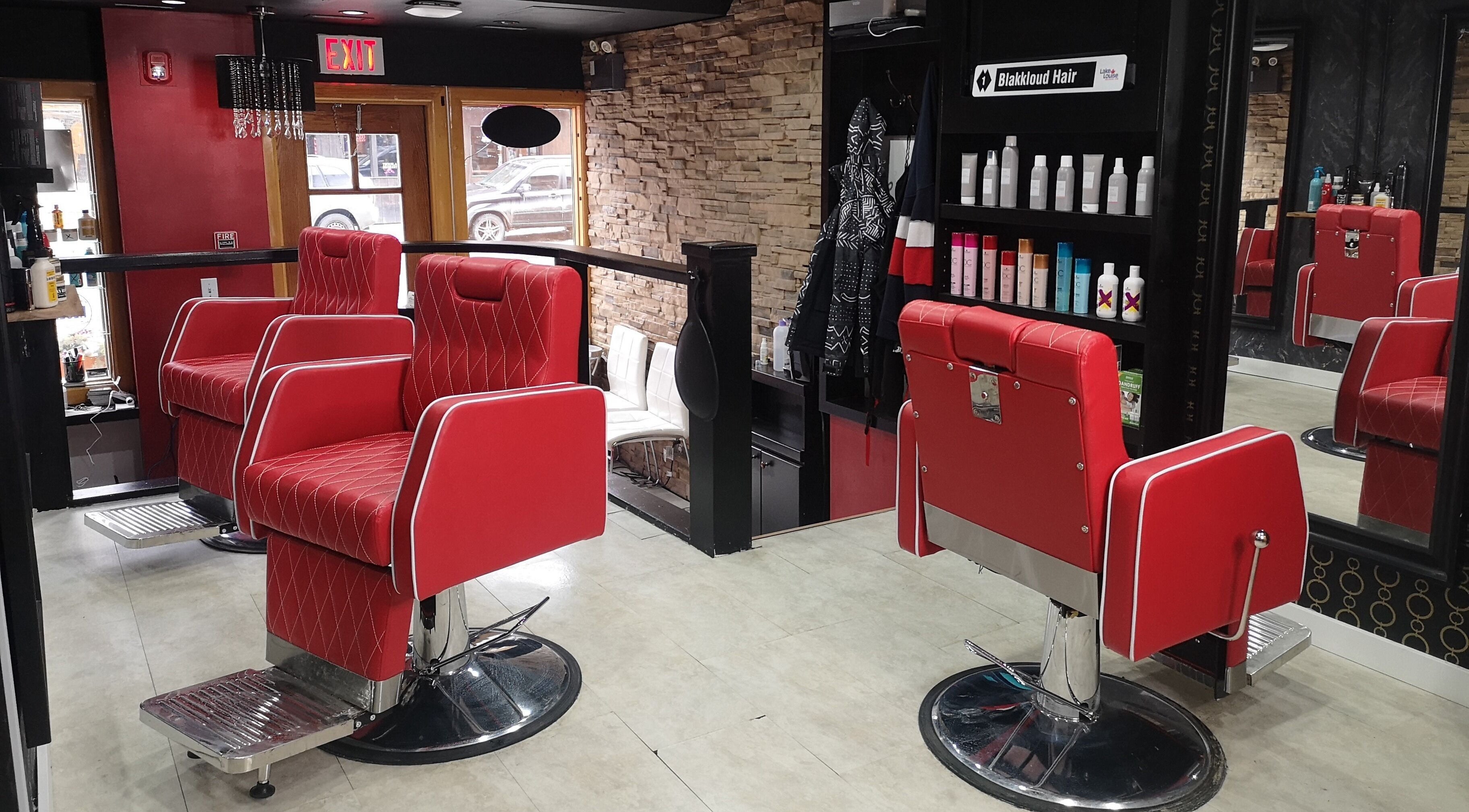 Chic red salon chairs at Blakkloud, Banff, Alberta, CA. Luxury ambiance with stone wall and products displayed.