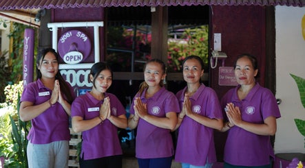 Smiling Yogi Spa team in purple uniforms at entrance in Bali, Bali, ID extending a warm welcome.