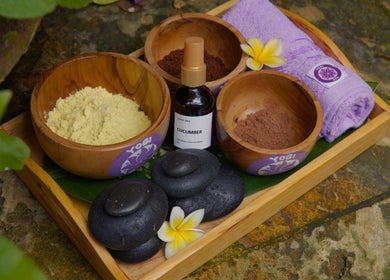 Relaxing spa essentials at Yogi Spa, Bali, Bali, ID featuring bowls, stones, and flowers.