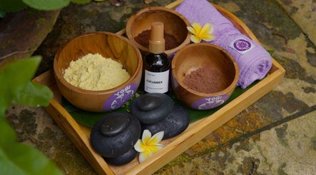 Relaxing spa essentials at Yogi Spa, Bali, Bali, ID featuring bowls, stones, and flowers.