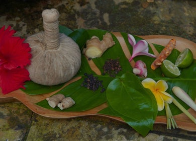 Traditional herbal remedies at Yogi Spa, Bali, Bali, ID, featuring fresh flowers and spices on a wooden platter.