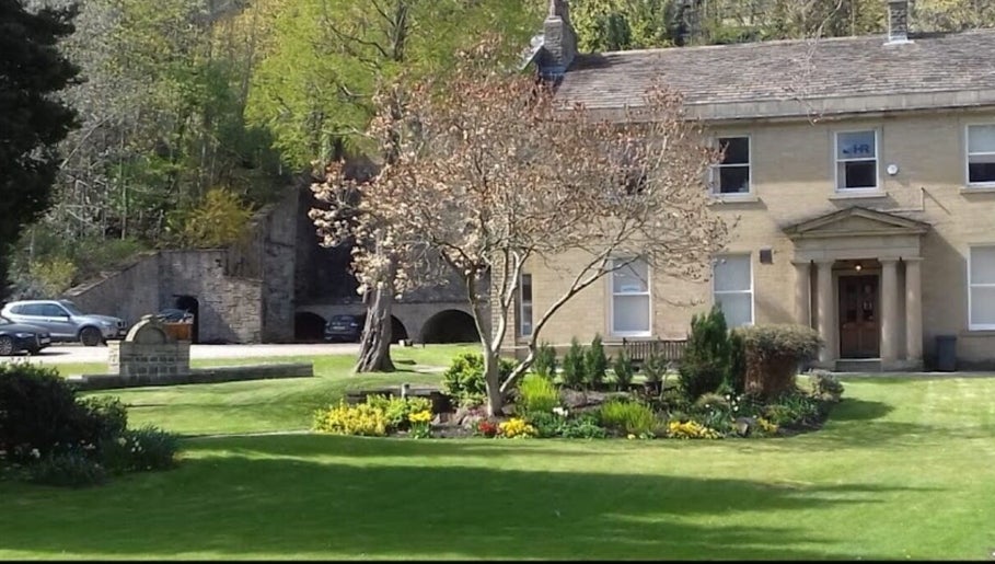Charming exterior of Alice Beauty in Huddersfield, England, GB surrounded by lush greenery.