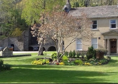 Charming exterior of Alice Beauty in Huddersfield, England, GB surrounded by lush greenery.