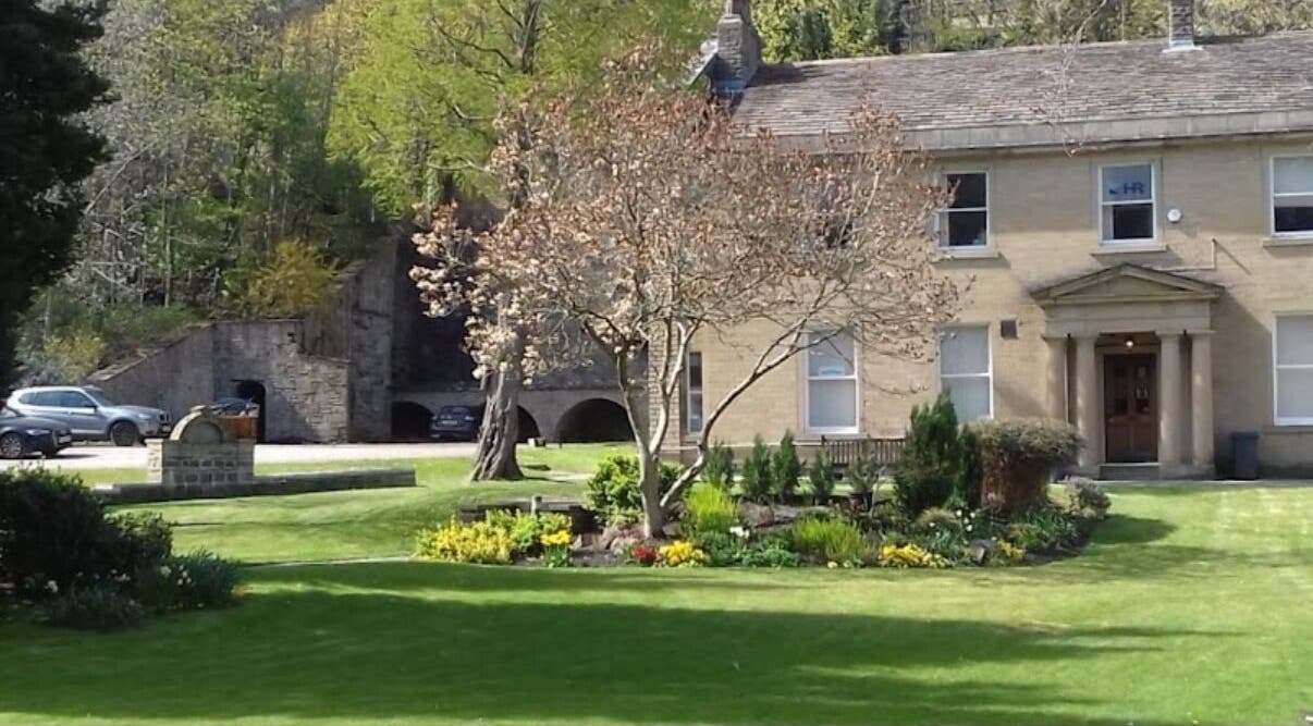 Charming exterior of Alice Beauty in Huddersfield, England, GB surrounded by lush greenery.