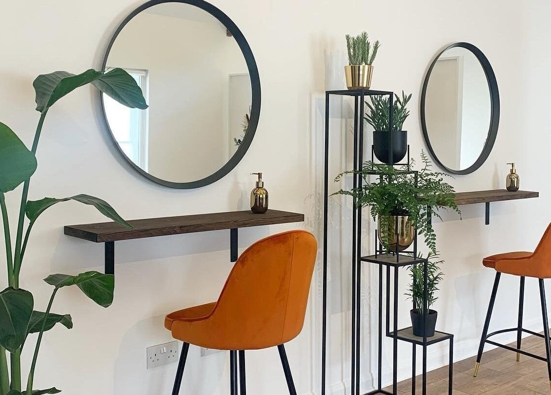 Modern salon interior with round mirrors and orange chairs at Flawless By Ffion, Abergavenny, Wales, GB.