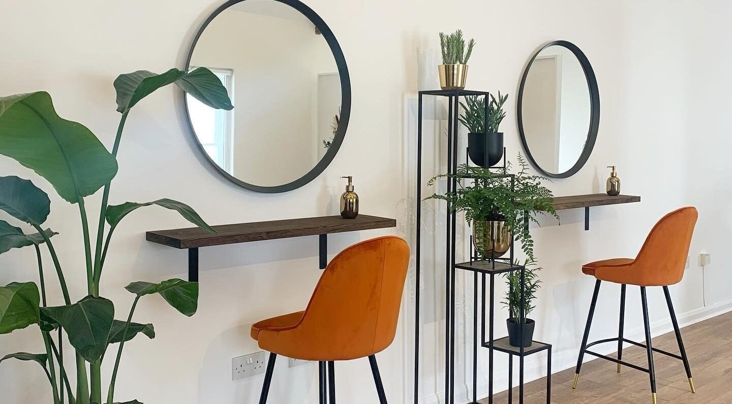Modern salon interior with round mirrors and orange chairs at Flawless By Ffion, Abergavenny, Wales, GB.