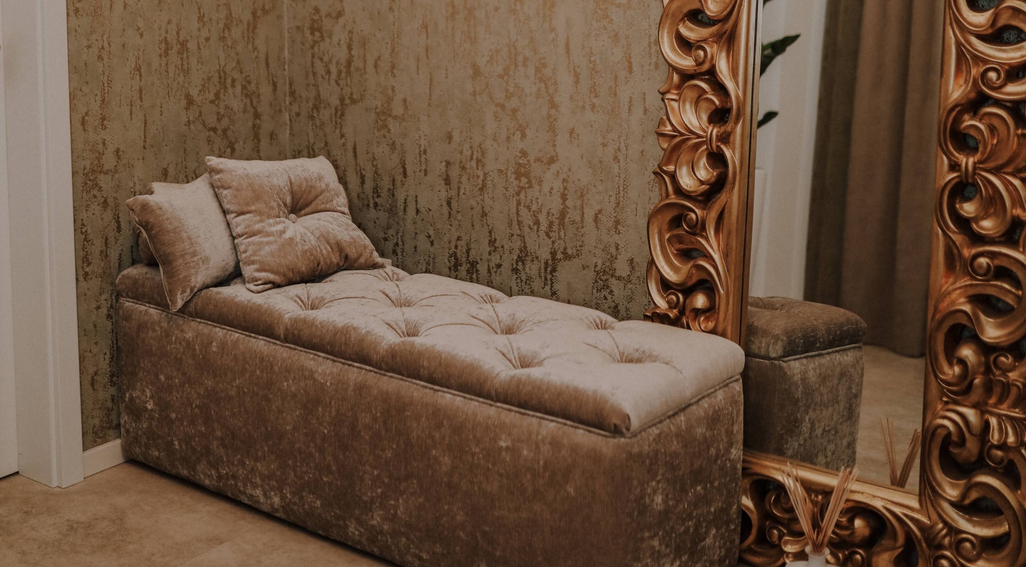 Elegantní pohovka v Quir - Clinic Lounge, Trnavský kraj, Trnavský kraj, SK, s vyřezávaným zrcadlem v pozadí.