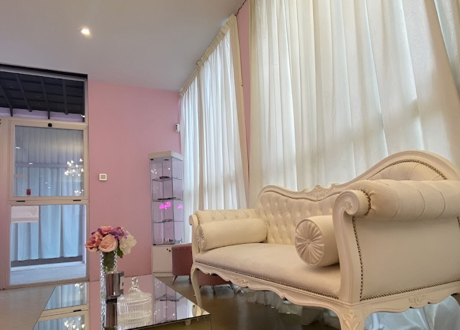 Elegante sala de Rich Beauty Studio en Castelar, Provincia de Buenos Aires, AR, con sofá blanco y flores decorativas.